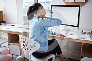 Long hours will take their toll. Shot of a businesswoman experiencing back pain while working at her desk in a modern