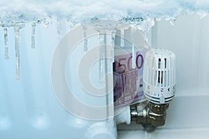 Long ice icicles, freezes water, euro banknotes near radiator, temperature regulation in house with thermostat, saving heat,