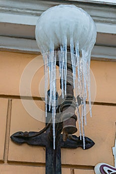 Long icicles adorn the street lamp. Winter