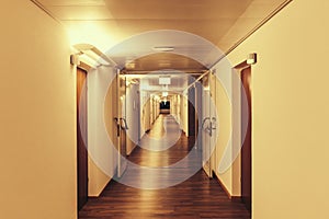 Long illuminated hallway, corridor, in residential building, clinic, retirement home