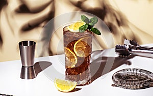 Long Island ice tea cocktail drink with vodka, rum, tequila, gin, liquor, lemon juice, cola and ice with lemon slice and mint in