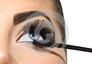 Long lashes closeup. Beautiful woman applying mascara on her eyes