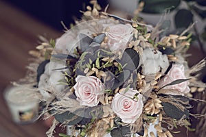 Long lasting flowers decoration. Preserved roses with dried flowers bouquet closeup. Selective focus on home decoration made of