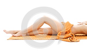 Long legs of relaxed lady with orange towel