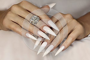 Long light manicure with ring.