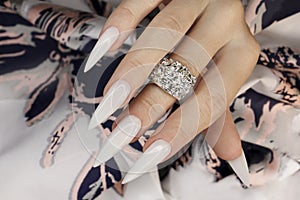 Long light manicure with ring.