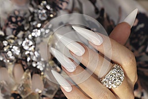 Long light manicure with ring.