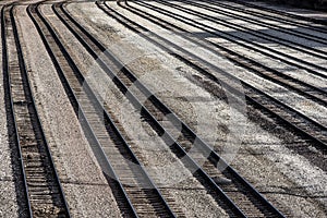 Long line of multiple railroad train tracks empty without trains in trainyard