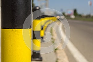 Long line of yellow and black traffic signs to deter the cars around the road photo