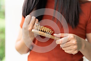 Long loss hair on woman brush with and woman looking at her hair