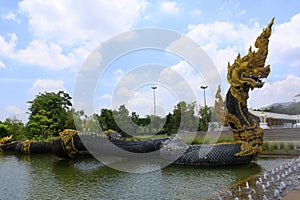 Long mighty dragon sculpture is a guard as well as a fountain placed near the entrance of the Buddhist temple at Ban Nong Chaeng