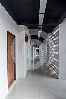 Long modern hotel corridor with sunlight through the wall