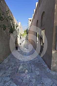 Long and narrow ally way in Dubai with brown buildings