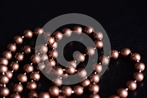 Long necklace of brown beads on a dark background