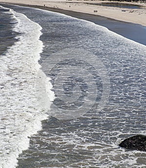 Long ocean waves on the sandy beach of Houtbay in the Western Cape