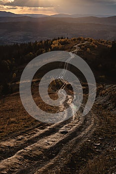 Long offroad in the mountains. Autumn range landscape during sunset time