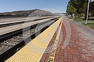 Long parallels merging train tracks and and platform converging into a blurred background