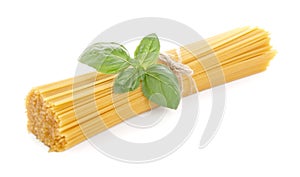 Long pasta raw isolated with basil leaf on white background