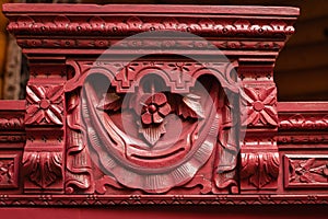 Long process of furniture patination. Red colored wooden cupboard with brilliant carved ornaments. Eco-friendly re-usage