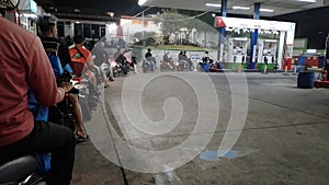 long queue of motorbikes at the gas station