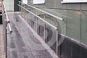Long ramp. Metal smooth handrails. Building wall