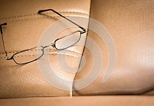 Long range eyeglasses left on passenger seat in the retro car.