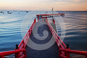 Long red bridge from beach shore in morning, Siracha, Chonburi