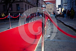 Long red carpet between rope barriers on entrance.