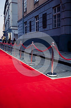 Long red carpet between rope barriers on entrance.