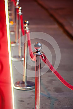 Long red carpet between rope barriers on entrance.