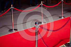 Long red carpet between rope barriers on entrance.