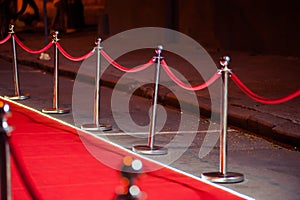 Long red carpet between rope barriers on entrance.