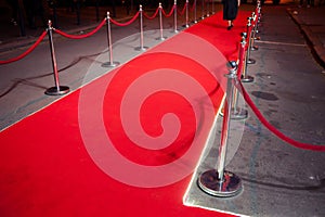 Long red carpet between rope barriers on entrance.