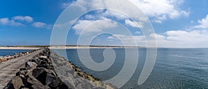 Long rocky storm groin and endless sandy beach on the Wadden Sea coast of western Denmark