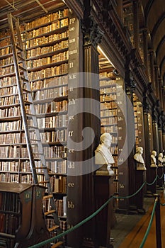 The Long Room interior Of The Old Library At Trinity College. Marble busts of great people and shelves with antique tomes