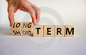 Long or short term symbol. Hand turns cubes and changes words `short term` to `long term`. Beautiful white background. Busines