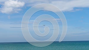 Long shot of an airplane over the sea