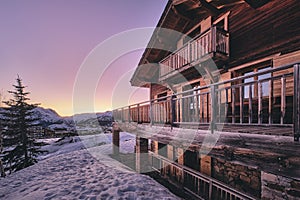 Long shot of the facade of a cabin in Alpe d Huez ski resort in the French Alps during sunrise photo