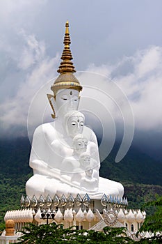 Long shot of five sitting white Buddhas and the foggy hills behind the Buddha at Pha Sorn Kaew, in Khao Kor, Phetchabun, Thailand.