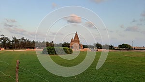 A long shot of a monument, Mahabalipuram or Mamallapuram,Tamil nadu, India.Shot also includes a beautiful meadow,trees and sky.