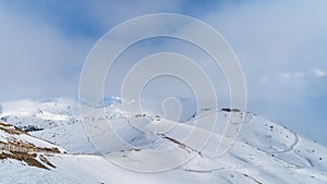 Long ski pistes and ski lifts winding through snow capped Pyrenees mountains in Andorra