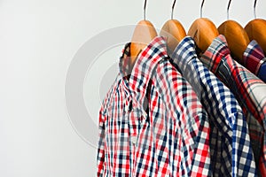 Long sleeve red and blue checkered shirt on wooden hanger over white background
