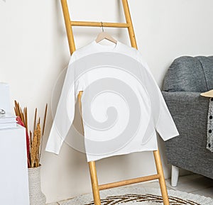 Long sleeve shirt hanged on to a ladder with minimalistic decorations