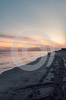 Long and solitary sandy beach in sunset