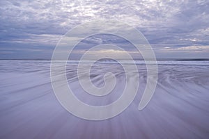 Long speed shutter of tropical sandy beach with sky and clouds over sea