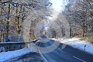 straight long hillside road in wintee forest
