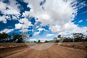 Long straight red dirt road in Australia`s outback