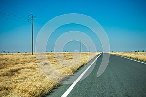 Long straight road near Corfield in rural Australia with traveller