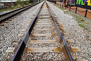 A long stretch of metal and wooden railroad tracks surrounded by gravel in the Marietta Square