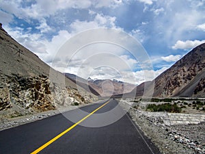 long stretch of road in the middle of mountainous area with mountains
